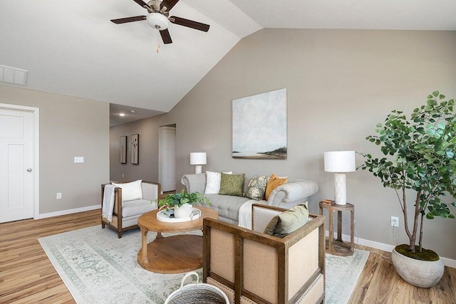 living room with lofted ceiling, ceiling fan, and light hardwood / wood-style flooring