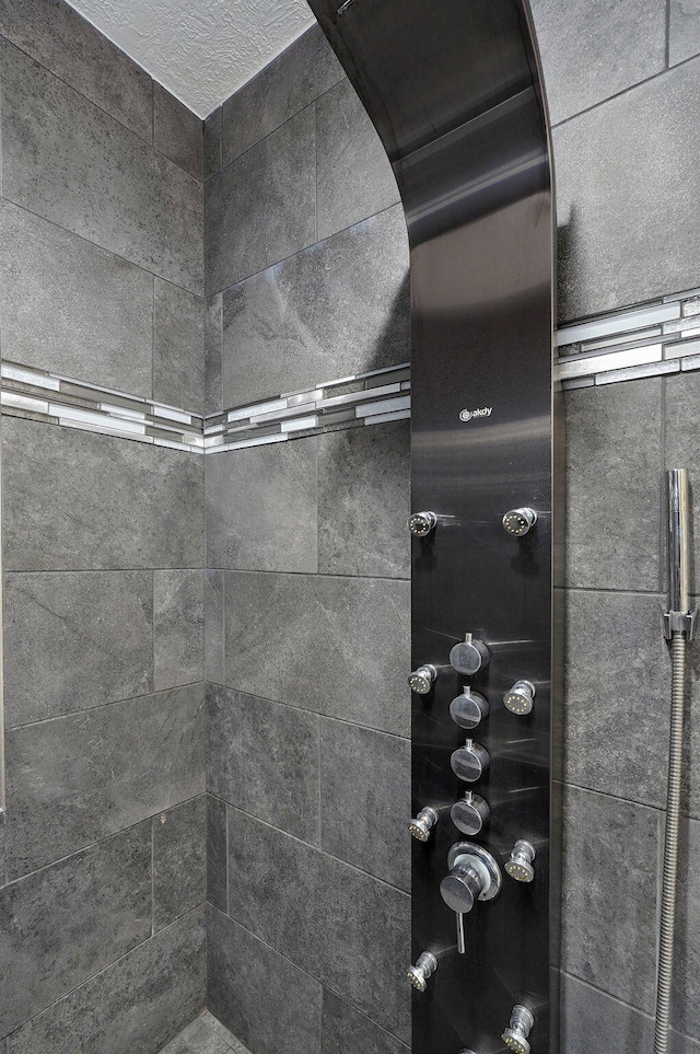 interior details featuring tiled shower