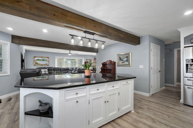 kitchen featuring white cabinetry, light wood-type flooring, a kitchen island, and beamed ceiling