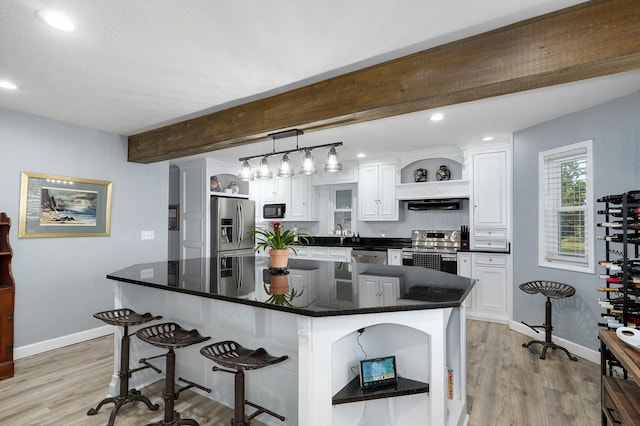 kitchen with pendant lighting, white cabinetry, stainless steel appliances, and a kitchen island