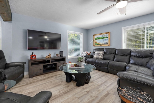 living room featuring a textured ceiling, ceiling fan, and light hardwood / wood-style flooring