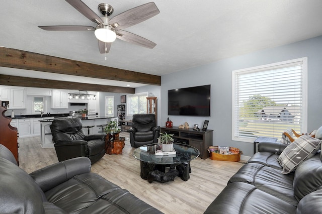 living room with beam ceiling, ceiling fan, and light hardwood / wood-style floors