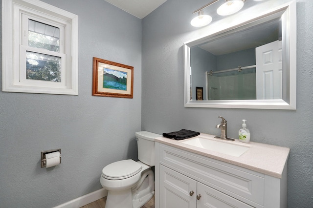 bathroom with walk in shower, vanity, and toilet