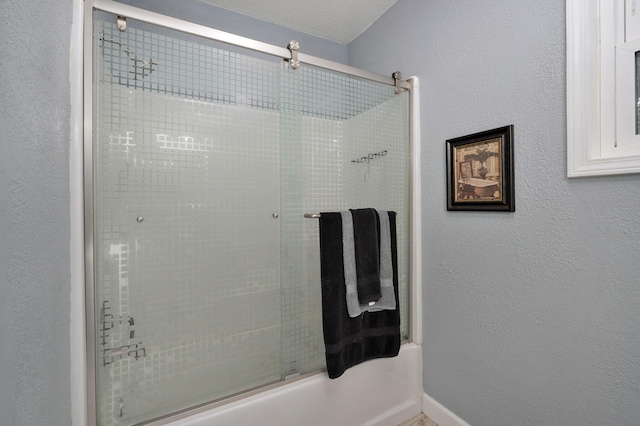 bathroom with combined bath / shower with glass door