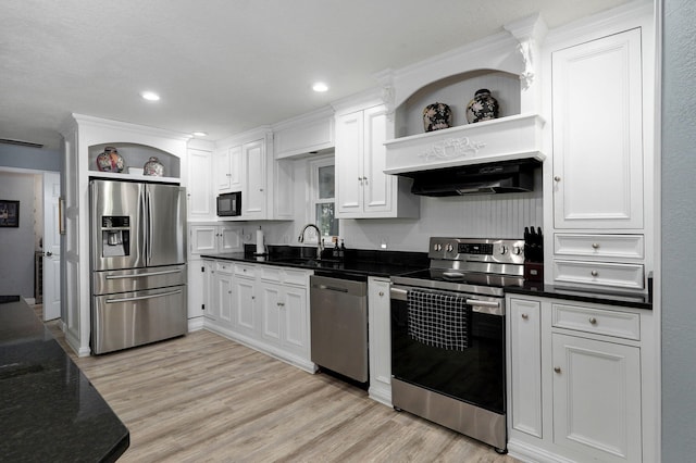 kitchen with stainless steel appliances, sink, white cabinets, and light hardwood / wood-style flooring