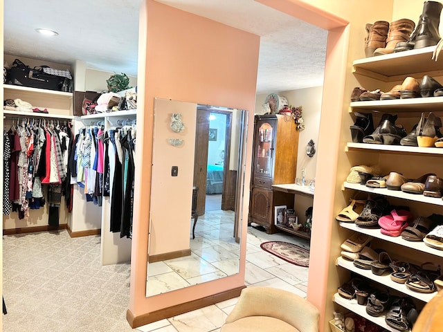 walk in closet featuring light carpet