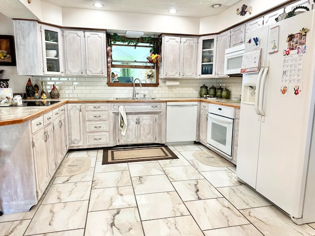 kitchen featuring white cabinets, white appliances, sink, and backsplash