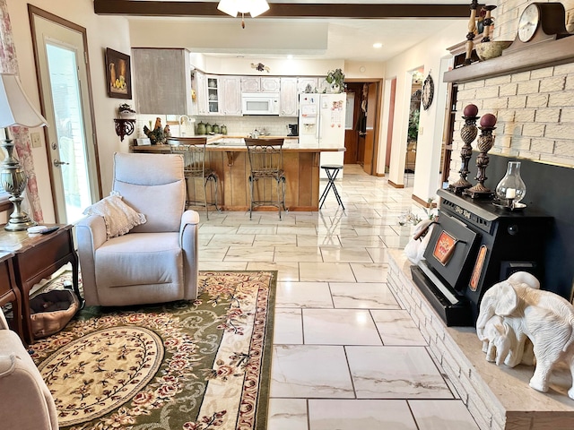 living room with ceiling fan and beamed ceiling