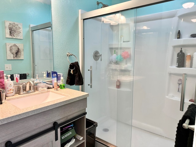 bathroom featuring vanity and a shower with shower door