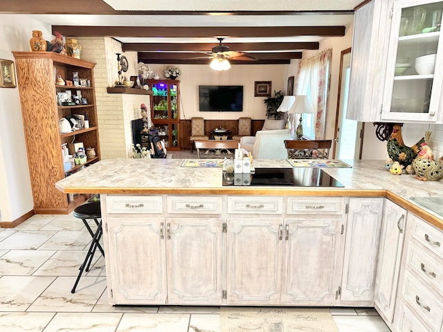 kitchen featuring kitchen peninsula, beamed ceiling, a kitchen breakfast bar, and ceiling fan