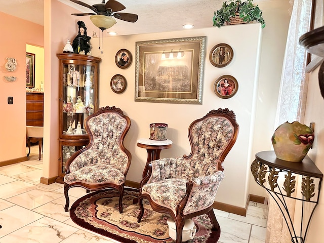 living area featuring a textured ceiling and ceiling fan