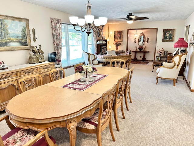 carpeted dining space with ceiling fan with notable chandelier and a textured ceiling