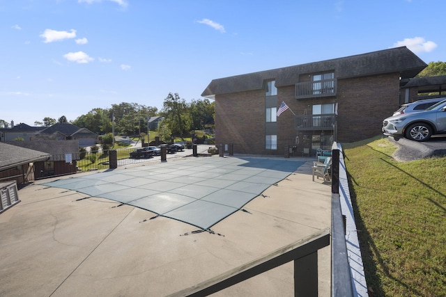 view of pool with a patio and a lawn