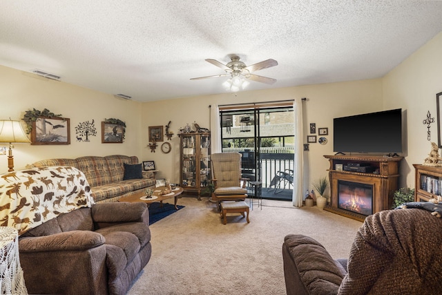 carpeted living room with ceiling fan and a textured ceiling