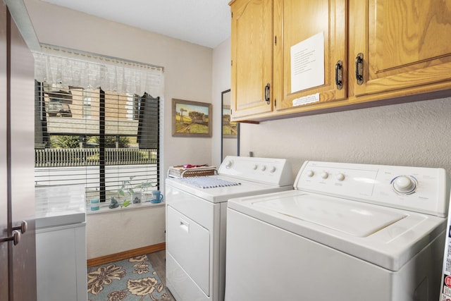 clothes washing area with baseboards, cabinet space, dark wood-style floors, and independent washer and dryer