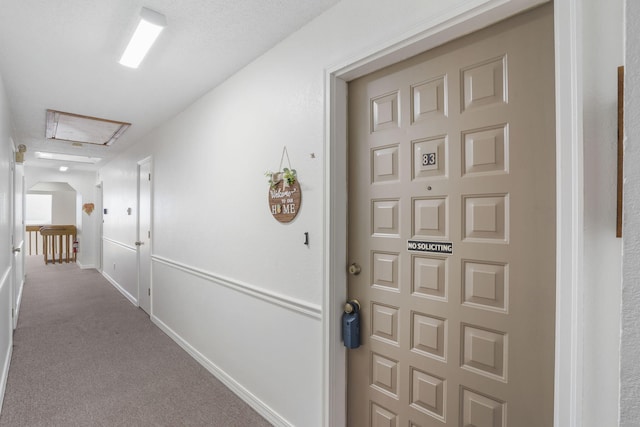 corridor featuring baseboards and carpet floors