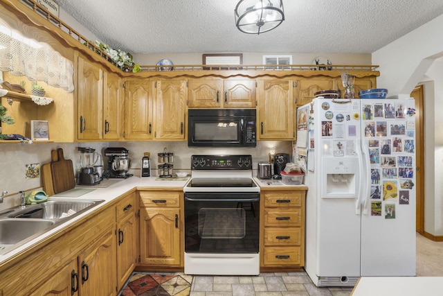 kitchen featuring white appliances, sink, and a textured ceiling