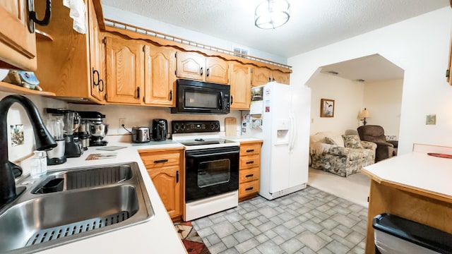 kitchen with light countertops, visible vents, a sink, white appliances, and open floor plan