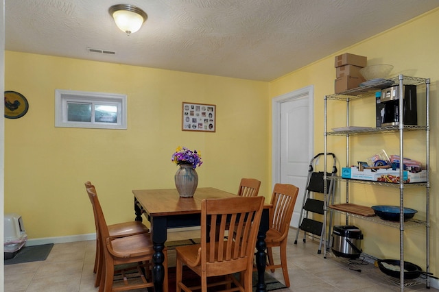 tiled dining room with a textured ceiling