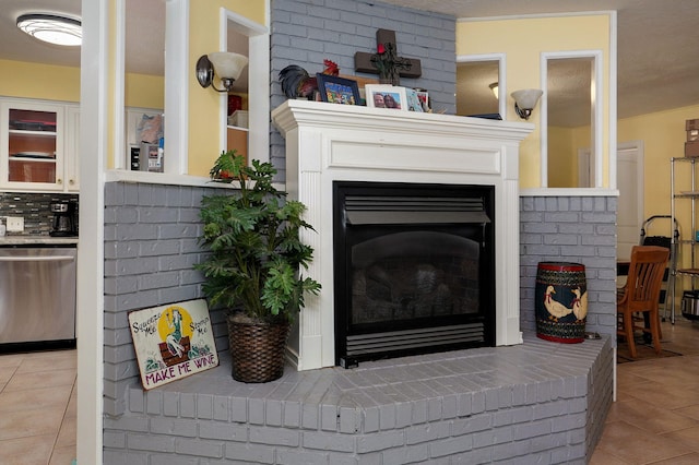 room details with decorative backsplash, dishwasher, a fireplace, tile patterned flooring, and a textured ceiling