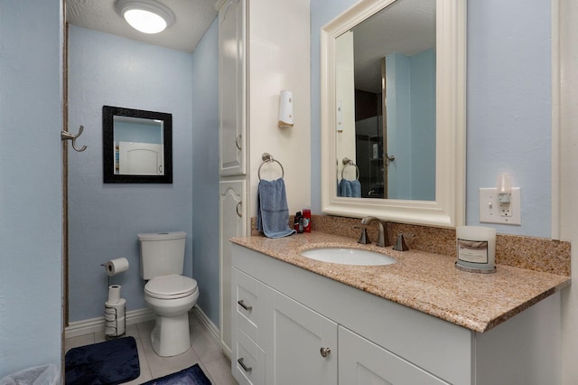 bathroom with vanity, tile patterned flooring, toilet, and a textured ceiling