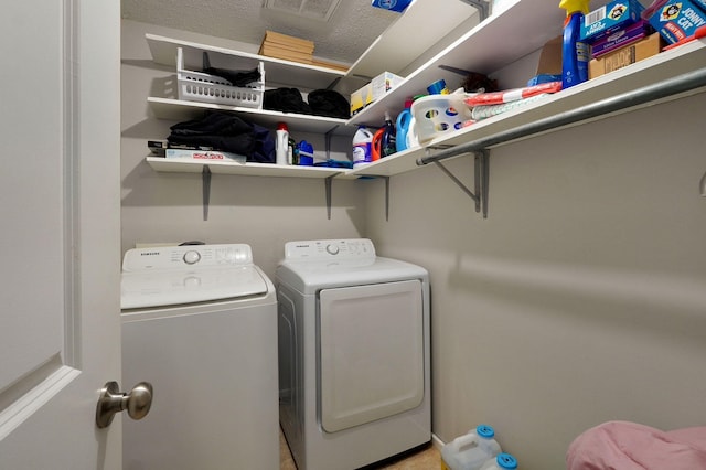 laundry room with washing machine and dryer and a textured ceiling