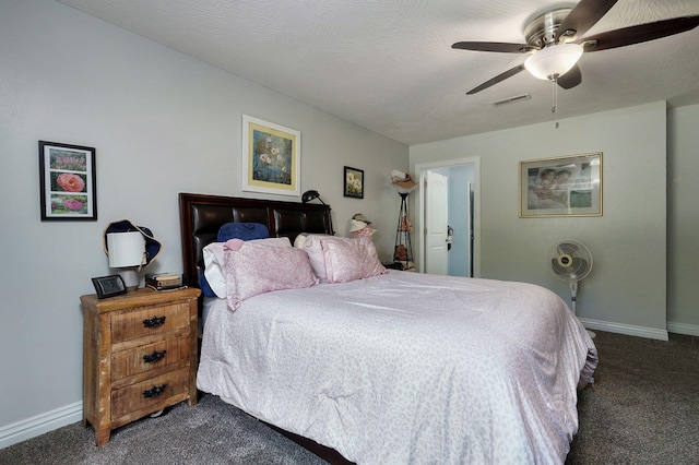 bedroom with dark colored carpet, ceiling fan, and a textured ceiling