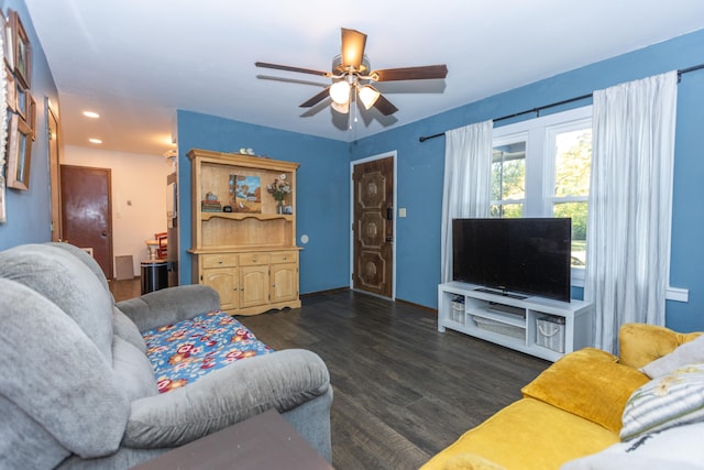 living room featuring ceiling fan and dark wood-type flooring