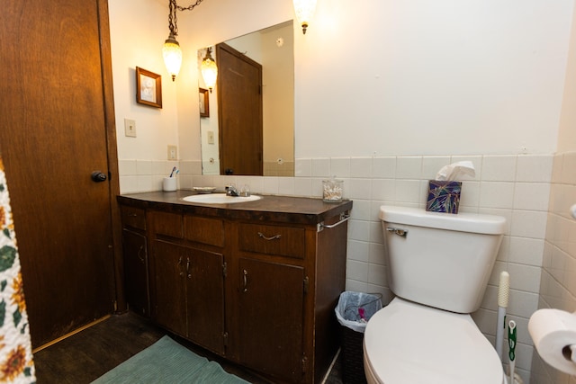 bathroom with tile walls, vanity, and toilet