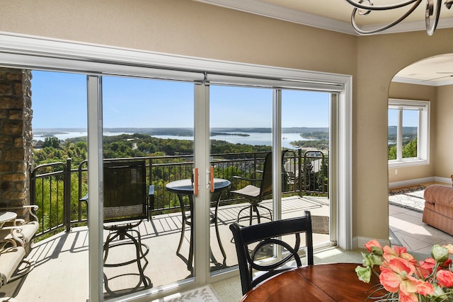 sunroom / solarium with ceiling fan and a water view