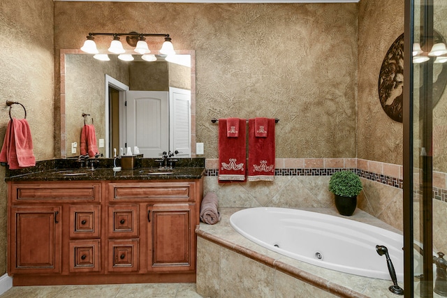 bathroom with a relaxing tiled tub, tile patterned flooring, and vanity