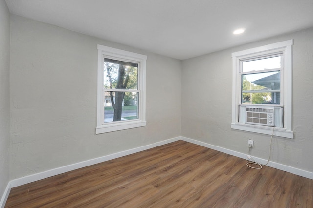 spare room featuring cooling unit and hardwood / wood-style floors