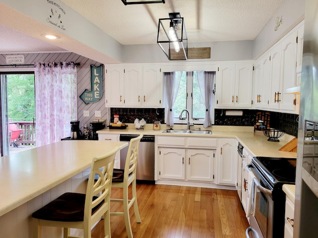 kitchen with sink, appliances with stainless steel finishes, a textured ceiling, and white cabinets