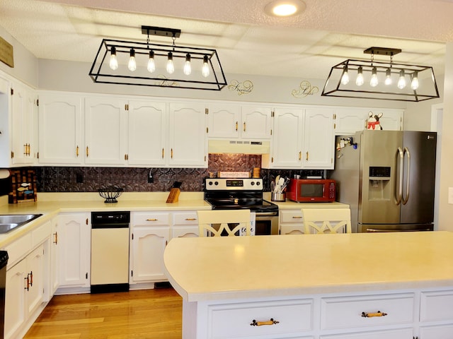 kitchen with appliances with stainless steel finishes, custom exhaust hood, white cabinets, and hanging light fixtures