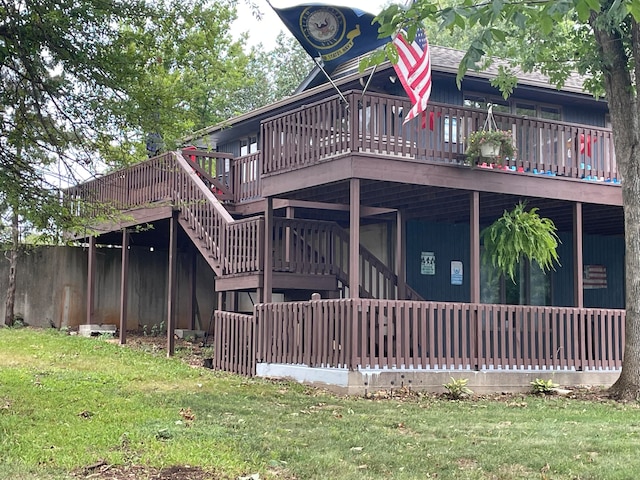 rear view of house with a wooden deck and a lawn