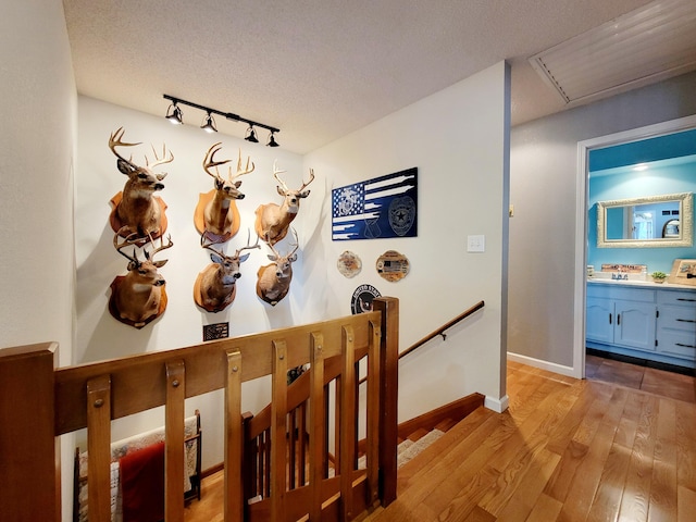 hallway featuring light hardwood / wood-style floors and a textured ceiling