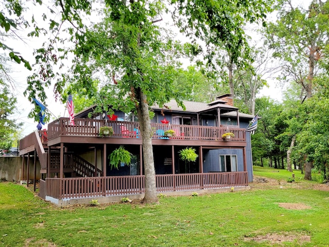 back of house with a deck and a yard