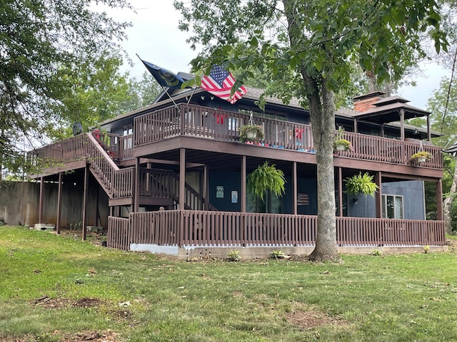 rear view of house featuring a yard and a deck