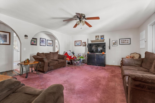 living area with arched walkways, carpet floors, and a ceiling fan