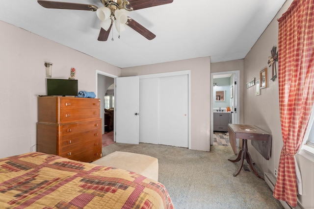 carpeted bedroom featuring a closet, a ceiling fan, baseboard heating, and connected bathroom