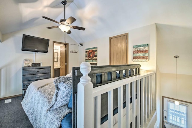 bedroom featuring ceiling fan, connected bathroom, vaulted ceiling, and dark carpet