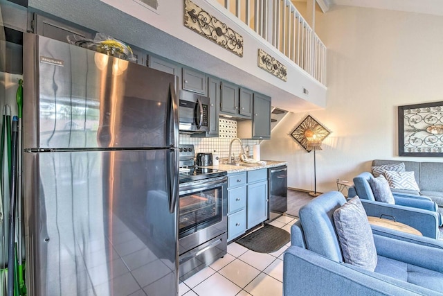 kitchen with gray cabinetry, sink, decorative backsplash, appliances with stainless steel finishes, and light tile patterned floors