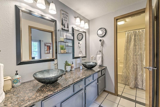 bathroom featuring vanity, shower / bath combo with shower curtain, a textured ceiling, and tile patterned floors