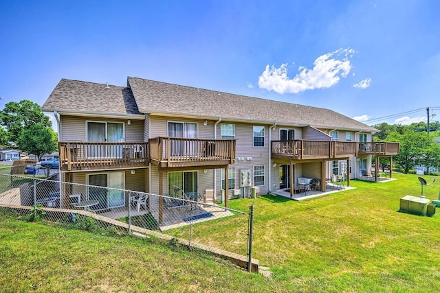 back of property featuring a deck, a lawn, and a patio area