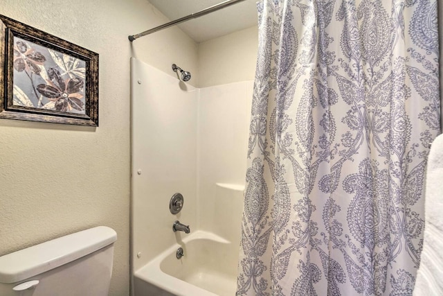 bathroom with shower / bath combination with curtain and toilet