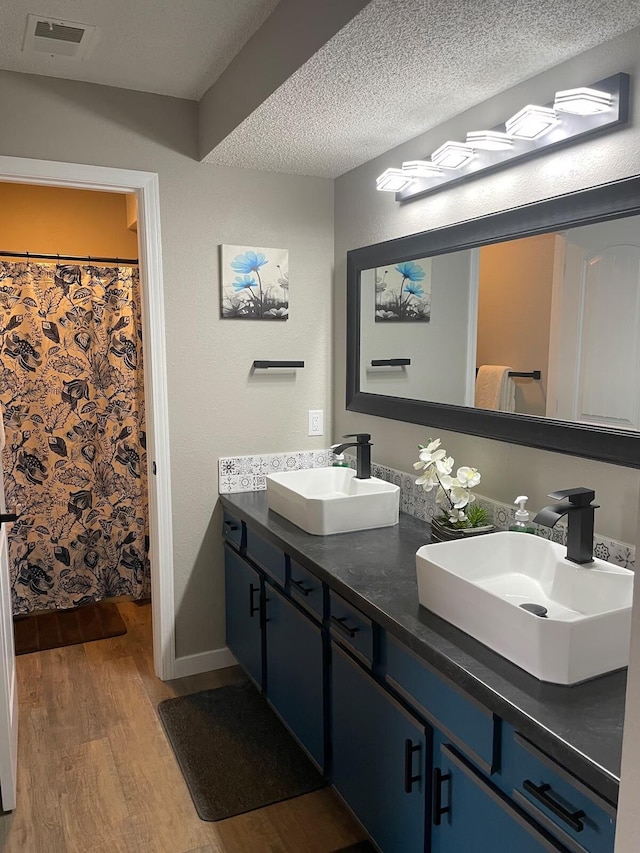 16 Fall Creek Trl Unit 2, Branson, MO 65616 - full bathroom featuring wood finished floors, double vanity, and a textured ceiling