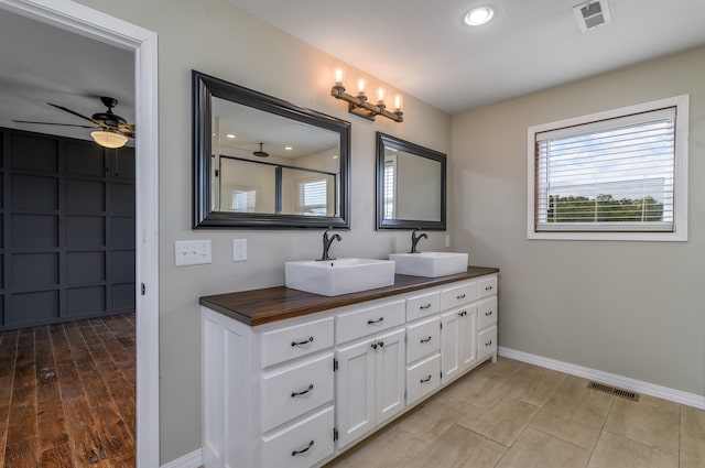 bathroom featuring hardwood / wood-style floors, ceiling fan, vanity, and a shower