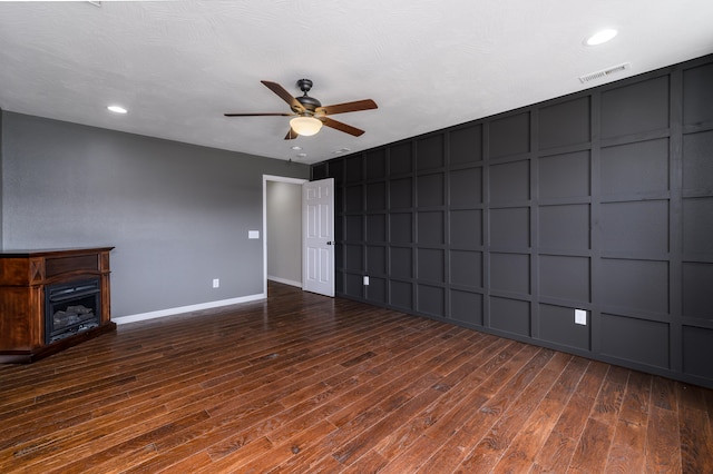 unfurnished living room featuring ceiling fan and dark hardwood / wood-style floors