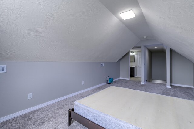 bedroom featuring lofted ceiling and carpet flooring