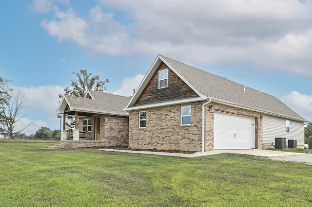 exterior space featuring a garage, a front lawn, and central AC